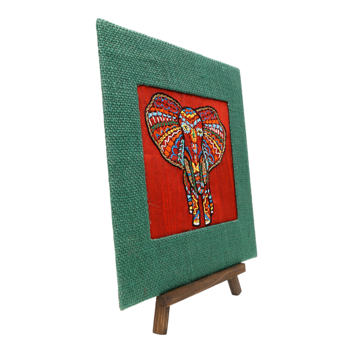 Indha Hand-Embroidered African Elephant – Silk Textile Art with Mini Wooden Easel A vibrant elephant motif stitched on rich silk—tabletop ready, gift-ready
