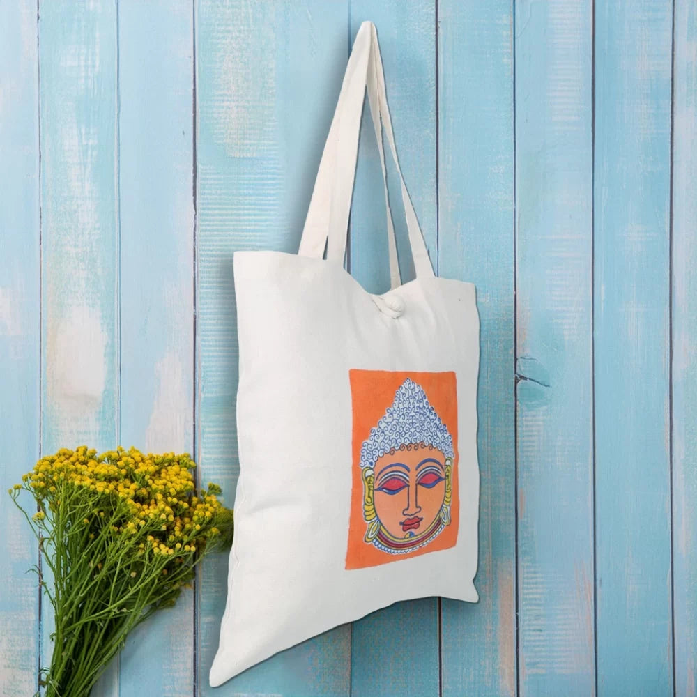 Indha Tote Bag with Lord Buddha Face Print |  Hand Block Printed Natural Cotton Shopping Bag | White and Orange Tote Bag | Eco-Friendly Handcrafted Tote | Single Compartment with Small Pocket | Button Closure | Vibrant and Spacious Bag |
